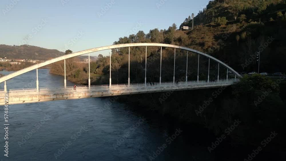 Aerial shot over a bridge with pedestrians walking on it in the River Miño in Spain. Aerial shot over a bridge with pedestrians walking on it in the River Miño in Spain.