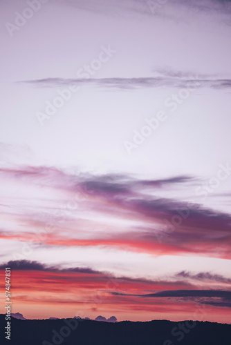 Soft pink, violet, and purple puffy clouds stretching upwards as if reaching for the heavens. (ID: 574847831)