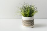 On a wooden table with a white background, there is artificial grass in a pot. the idea of a comfortable home and workplace, as well as lifestyle. Mockup your content with copy space. Generative AI