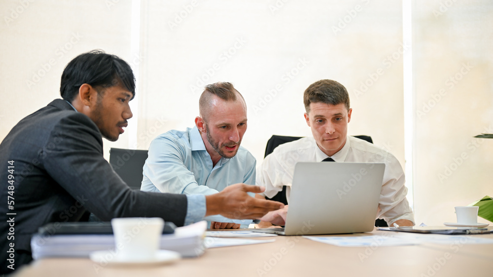 Professional business financial analysts are discussing work, looking at laptop screen Professional business financial analysts are discussing work, looking at laptop screen