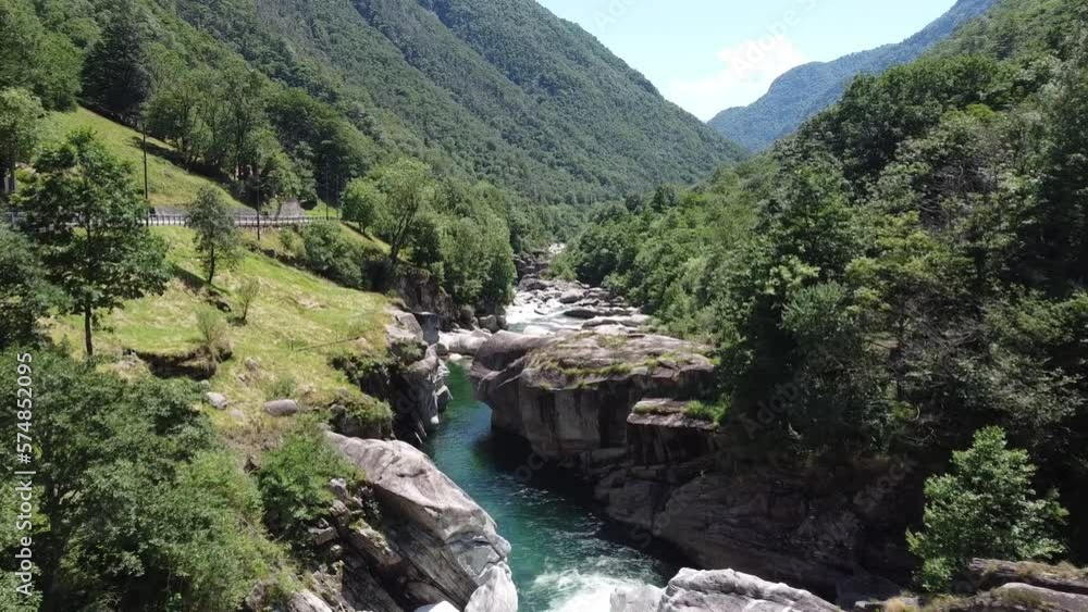Slow aerial flight of natural river between rocks and green mountains In Switzerland Slow aerial flight of natural river between rocks and green mountains In Switzerland