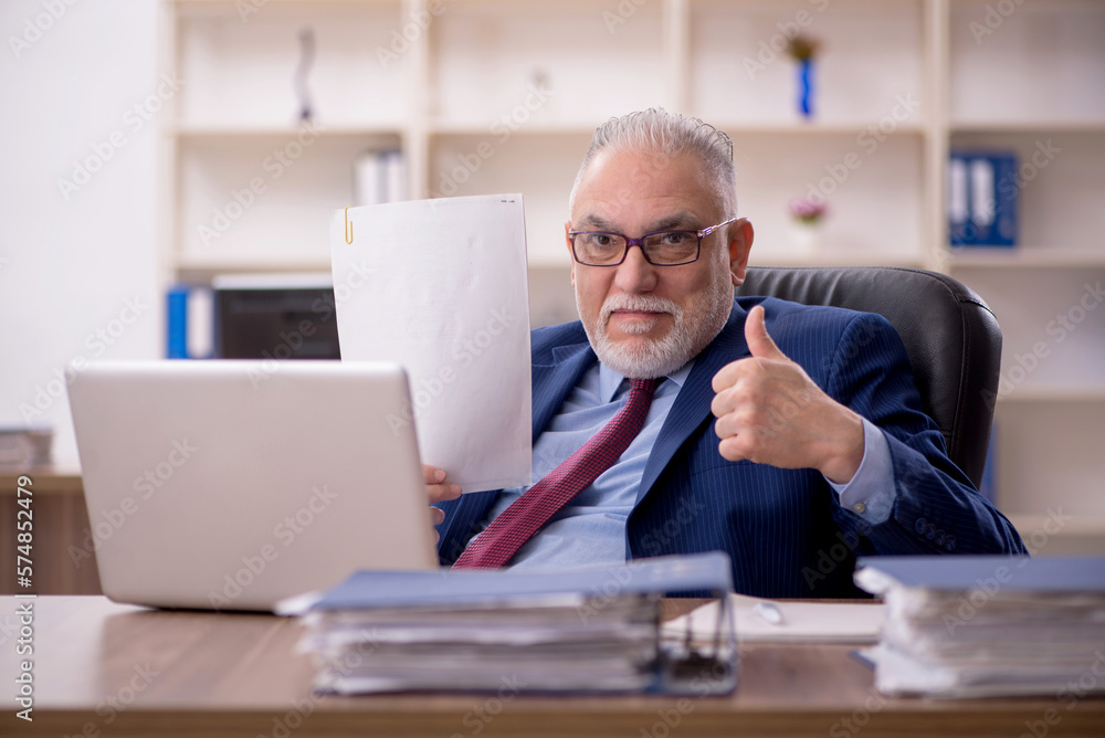 Old male employee working in the office Old male employee working in the office