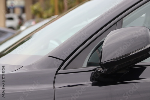 Car sleek side view mirrors/ Sports car side profile image, glossy black color. Modern supercar. Sleek glass reflective background. With copy space. Newly washed car. Exotic cars. Black sleek car.