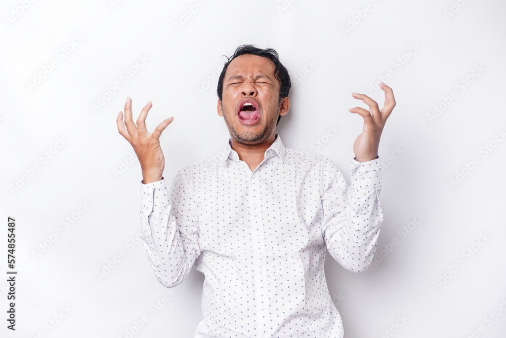 Naklejka premium A portrait of an Asian man wearing a white shirt isolated by white background looks depressed