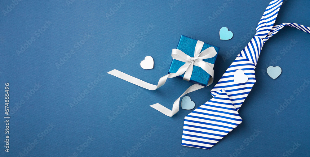 Gift box with white ribbon bow and tie on blue background, happy fathers day concept - obrazy, fototapety, plakaty 