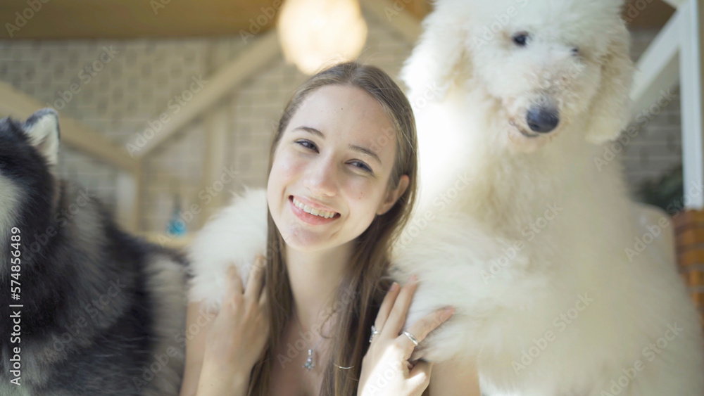 Portrait of caucasian woman girl playing with dogs or puppy smiling in cafe restaurant. Pet animal. People lifestyle. Portrait of caucasian woman girl playing with dogs or puppy smiling in cafe restaurant. Pet animal. People lifestyle.