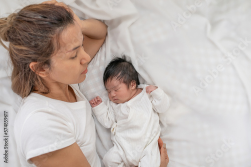 co-sleeping concept. closeup of mother and cute little baby napping together in bed, top view. beautiful woman and her little baby sleeping together in bedroom, Sweet dreams, maternity concept