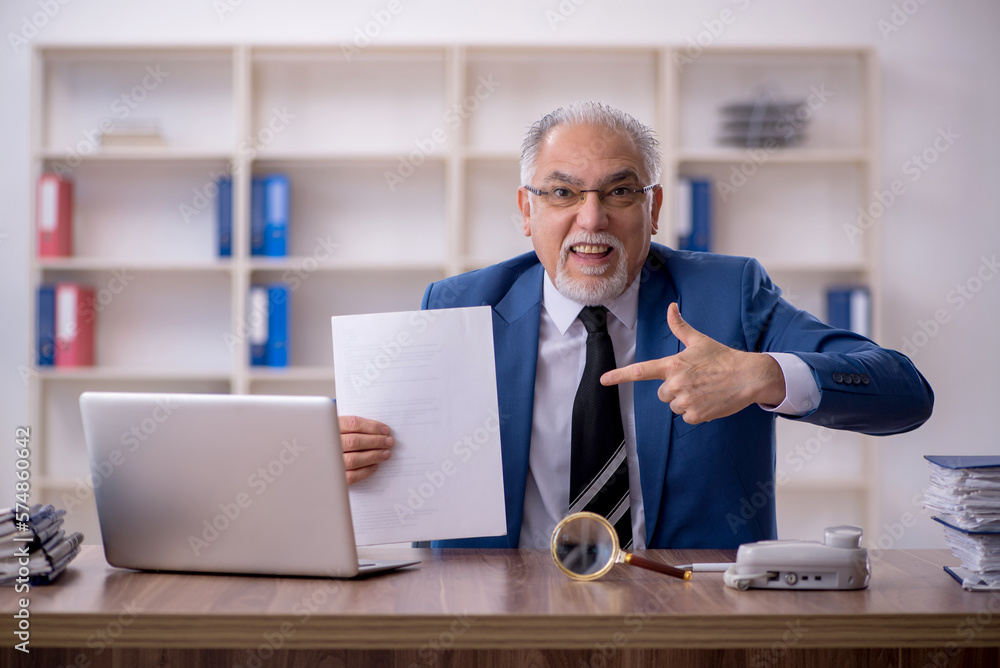 Old male employee working in the office Old male employee working in the office