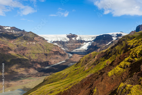 Skaftafel national park. Southern Iceland. Beautiful landscape of a white snowy mountain glacier coming down between two rocky slopes on a sunny day.