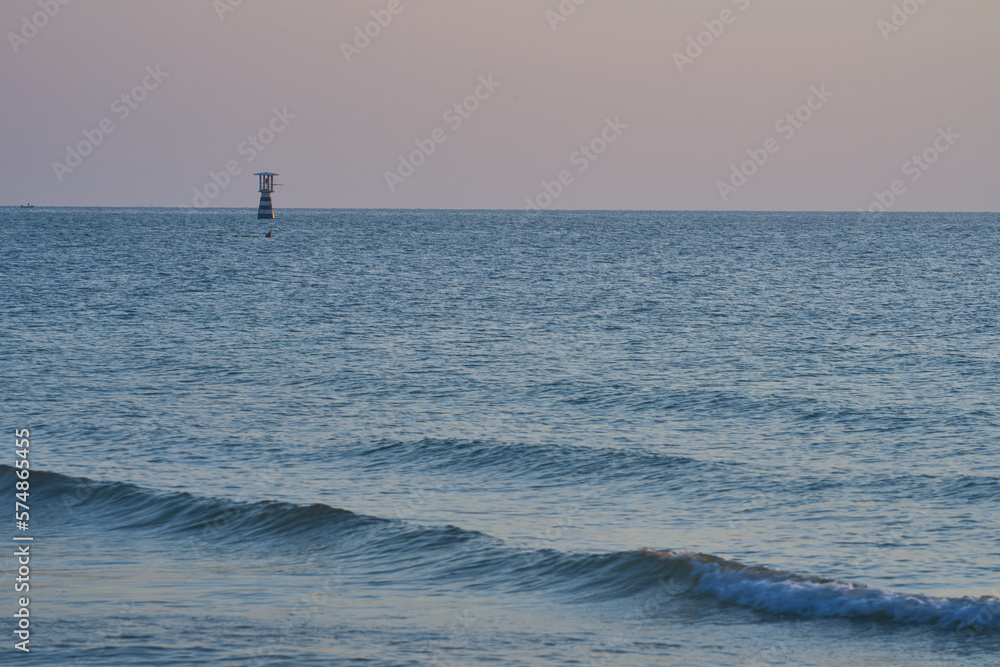 Fototapeta premium wave with blur floating lighthouses in the sea on blur sky background