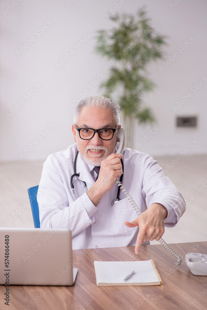 Old male doctor in telemedicine concept Old male doctor in telemedicine concept