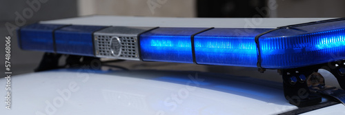 Blue lights on roof of police car in city photo