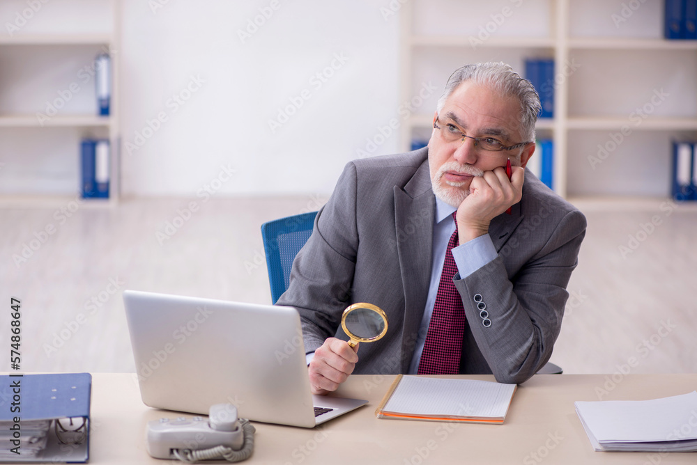 Old male employee working in the office Old male employee working in the office