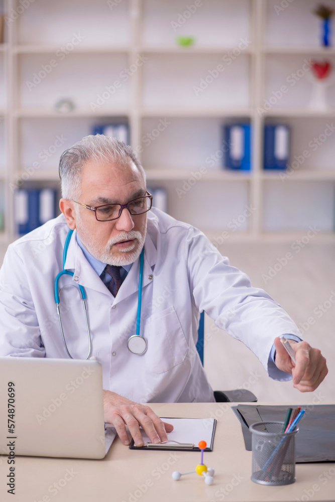 Old male doctor working in the clinic Old male doctor working in the clinic