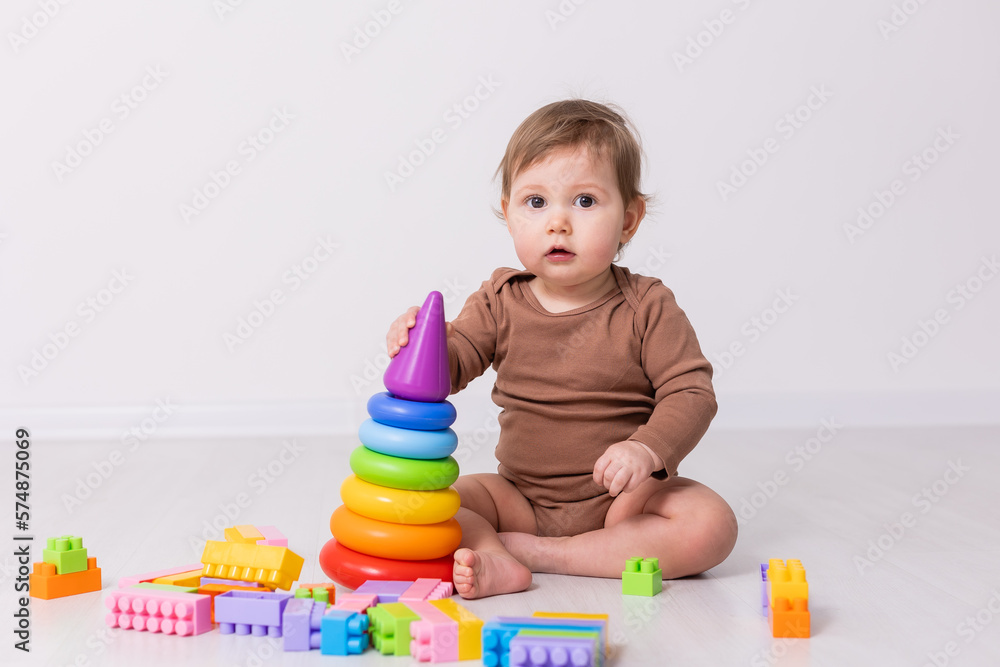 adorable baby in brown shirt playing with toys, card, banner, space for text adorable baby in brown shirt playing with toys, card, banner, space for text
