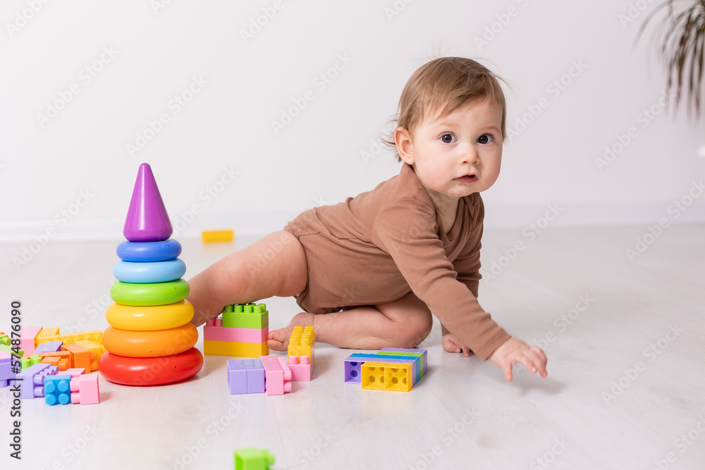 adorable baby in brown shirt playing with toys, card, banner, space for text adorable baby in brown shirt playing with toys, card, banner, space for text