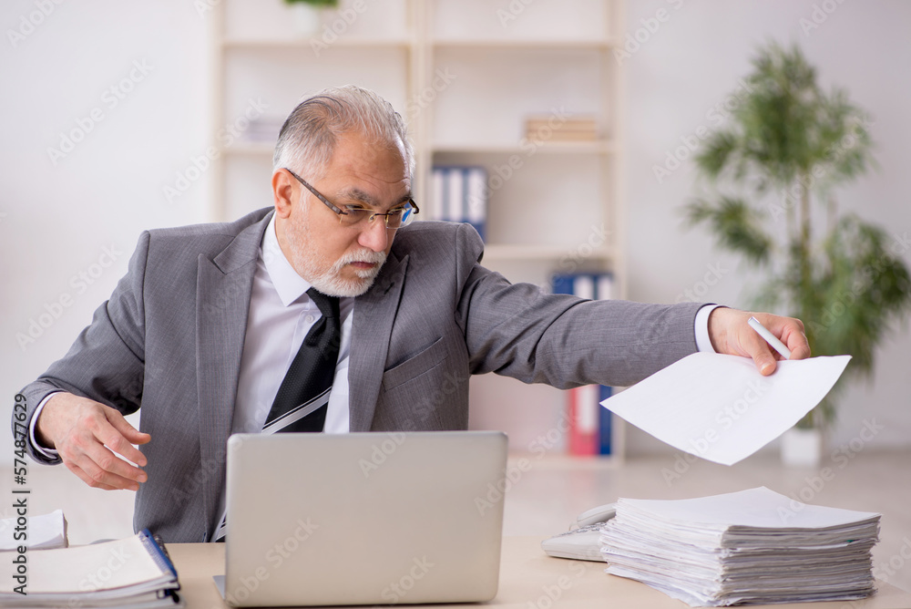 Old male employee working in the office Old male employee working in the office