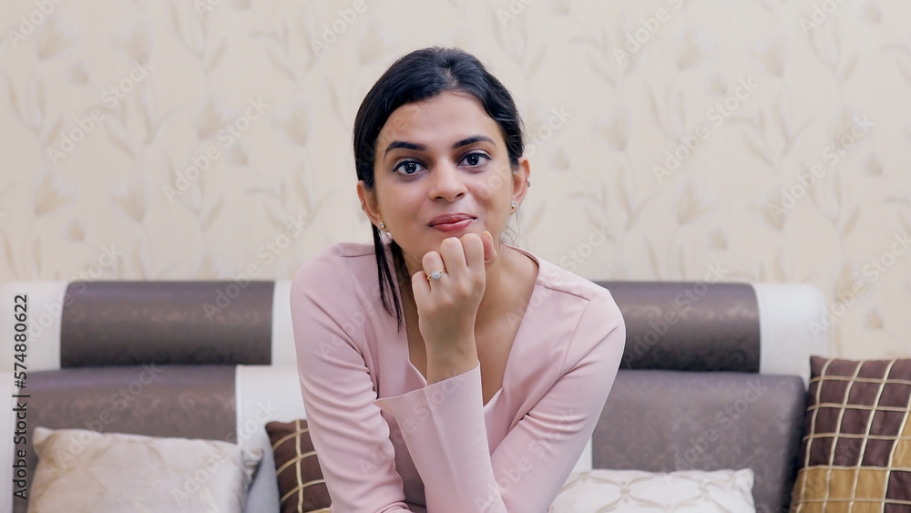 Medium shot of a beautiful young female talking while looking towards the camera. Point of view shot of a pretty Indian girl laughing while doing an online video call with her friend - technology c... - obrazy, fototapety, plakaty 