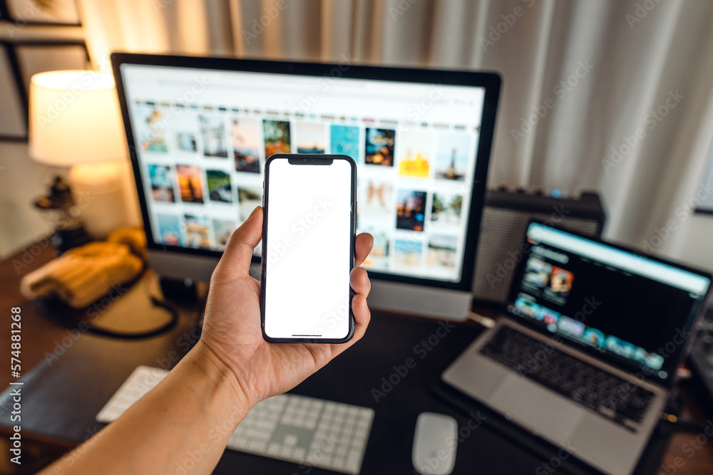 hand holding smartphone with blank screen in home desk hand holding smartphone with blank screen in home desk