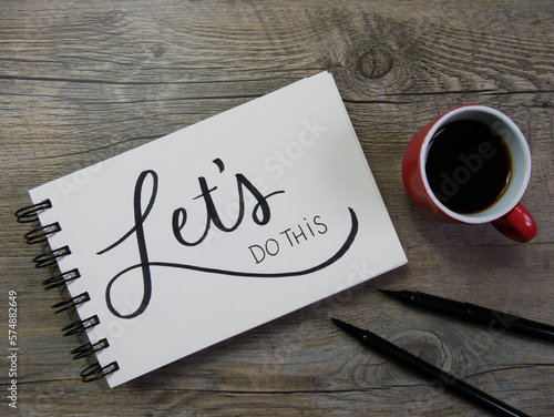 LET'S DO THIS lettering in notebook with cup of coffee and pens