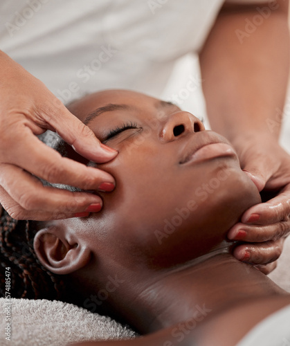 Black woman face, massage and spa wellness therapist with young female and cosmetic facial. Skincare, beauty and dermatology clinic with client feeling calm and zen from hyaluronic acid serum