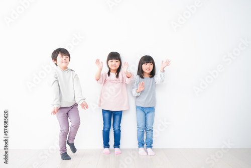 壁に並ぶ3人の子どもたち
