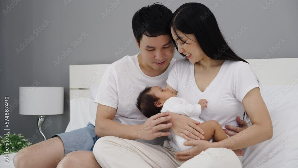 parent (mother and father) holding and consoling newborn baby to sleeping on a bed parent (mother and father) holding and consoling newborn baby to sleeping on a bed