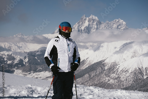 Portrait of skier on sunny day beautiful mountain peaks in the clouds on background