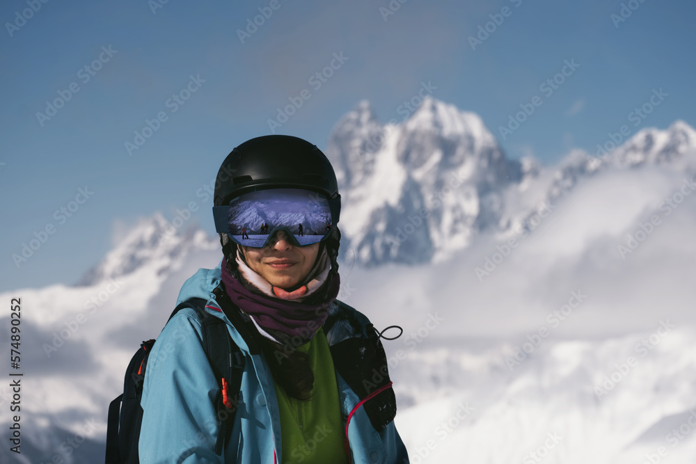 Face portrait of Snowboarder female beautiful mountain peaks covered with snow on background