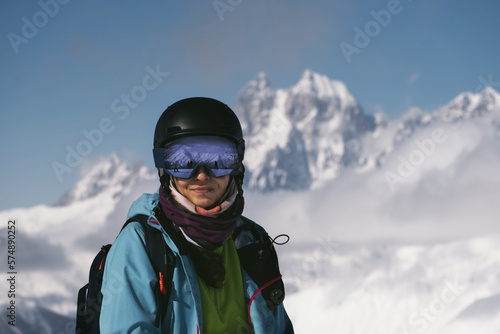 Face portrait of Snowboarder female beautiful mountain peaks covered with snow on background