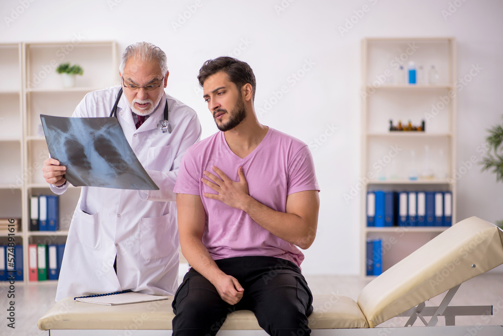Fototapeta premium Young male patient visiting old male doctor radiologist