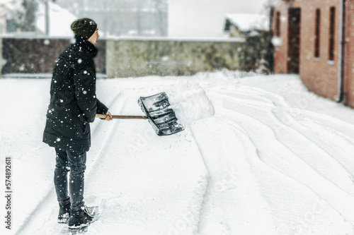 A man shovels snow with a shovel. Cleaning, winter, season, street, work