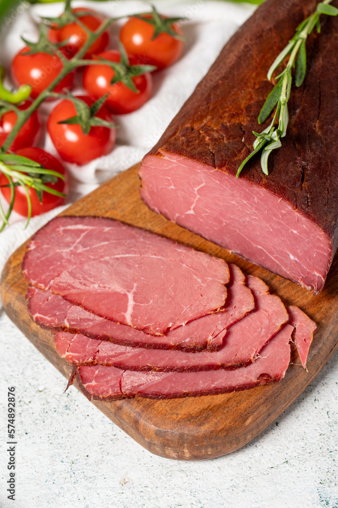 Dry meat. Slices of dried and smoked dry meat on a wooden board. Beef jerky pieces Dry meat. Slices of dried and smoked dry meat on a wooden board. Beef jerky pieces