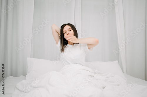 Image of beautiful woman resting in white bed at bedroom. in morning . Lifestyle at home concept.