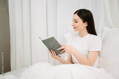 Portrait of Good Healthy young woman reading book and resting in bed at bedroom. lifestyle concept.