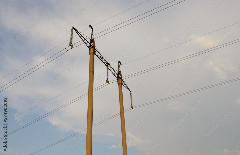 concrete poles with power lines against the sky at sunset. wires are stretched and are under high voltage. transmission of electricity over long distances concrete poles with power lines against the sky at sunset. wires are stretched and are under high voltage. transmission of electricity over long distances