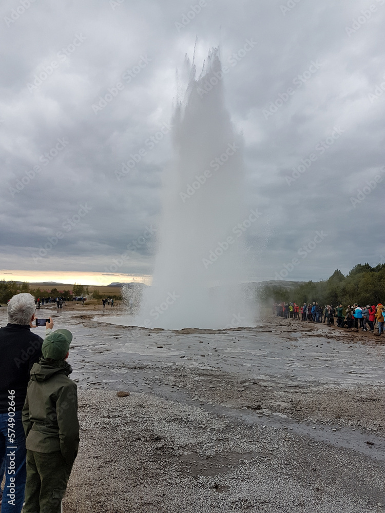 Obraz premium Tourists watching the geyser Strokkur erupt in Iceland
