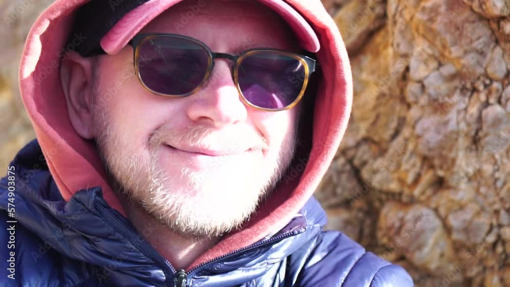 Portrait smiling bearded man in eyeglasses posing at sea beach landscape. Happy modern casual male tourist closeup face resting resort coastline seaside shore. Man Model Enjoying the Sea View Portrait smiling bearded man in eyeglasses posing at sea beach landscape. Happy modern casual male tourist closeup face resting resort coastline seaside shore. Man Model Enjoying the Sea View