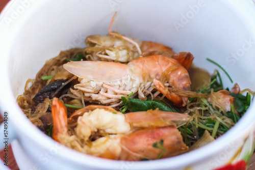 Steamed Prawns with Vermicelli in white hot pot Thai food background