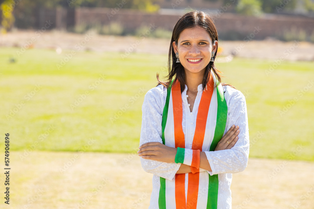 Portrait of young indian woman wearing traditional white kurta and tricolor duppata standing cross arms at park. Election and politics, celebrating Independence day or Republic day. Portrait of young indian woman wearing traditional white kurta and tricolor duppata standing cross arms at park. Election and politics, celebrating Independence day or Republic day.