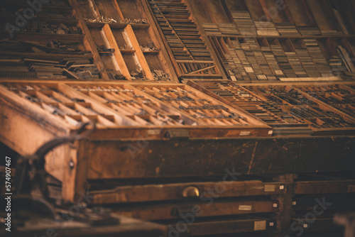 Antique wooden printing press boxes filled with metal plates used in historical printing. photo
