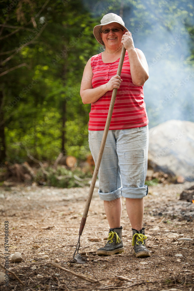 Portrait of a middle aged woman holding a garden rake. Portrait of a middle aged woman holding a garden rake.