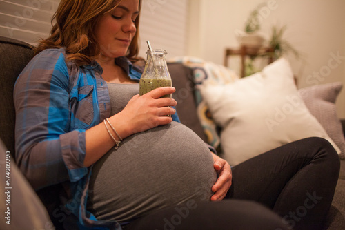 Pregnant woman drinking green smoothie at home, Langley, British Columbia, Canada photo
