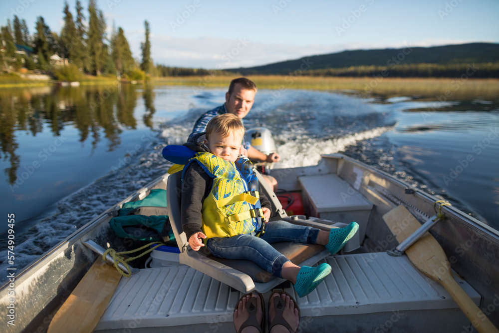 Father and son on motorboat in lake, Kamloops, British Columbia, Canada Father and son on motorboat in lake, Kamloops, British Columbia, Canada