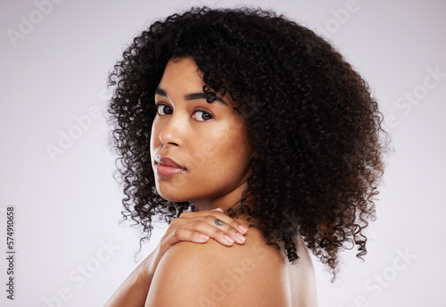Black woman, hair and afro in studio portrait with beauty, wellness and cosmetic skincare glow by background. Young gen z model, african and cosmetics with clean face, natural and healthy aesthetic