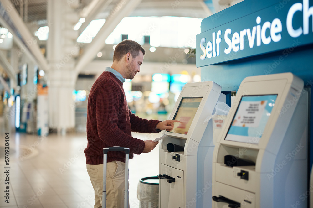 Man, airport and self service kiosk for check in, ticket registration or online boarding pass. Male traveler by terminal machine for travel application, document or booking flight with luggage