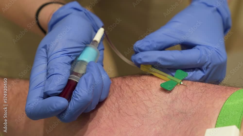 Doctor drawing blood to patient arm with butterfly needle and tubes. Close up. Doctor drawing blood to patient arm with butterfly needle and tubes. Close up.