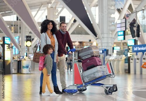 Travel, airport and happy family with suitcase trolley for holiday, vacation or immigration journey. Luggage of black woman or diversity parents with child or kid walking in lobby excited for flight