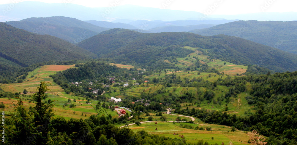 View of the village of Lipovets against the backdrop of the Ukrainian Carpathian mountains in the haze
