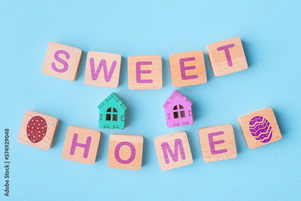 Toy houses and wooden blocks with words Sweet Home and Easter eggs icons. Easter holidays concept Toy houses and wooden blocks with words Sweet Home and Easter eggs icons. Easter holidays concept